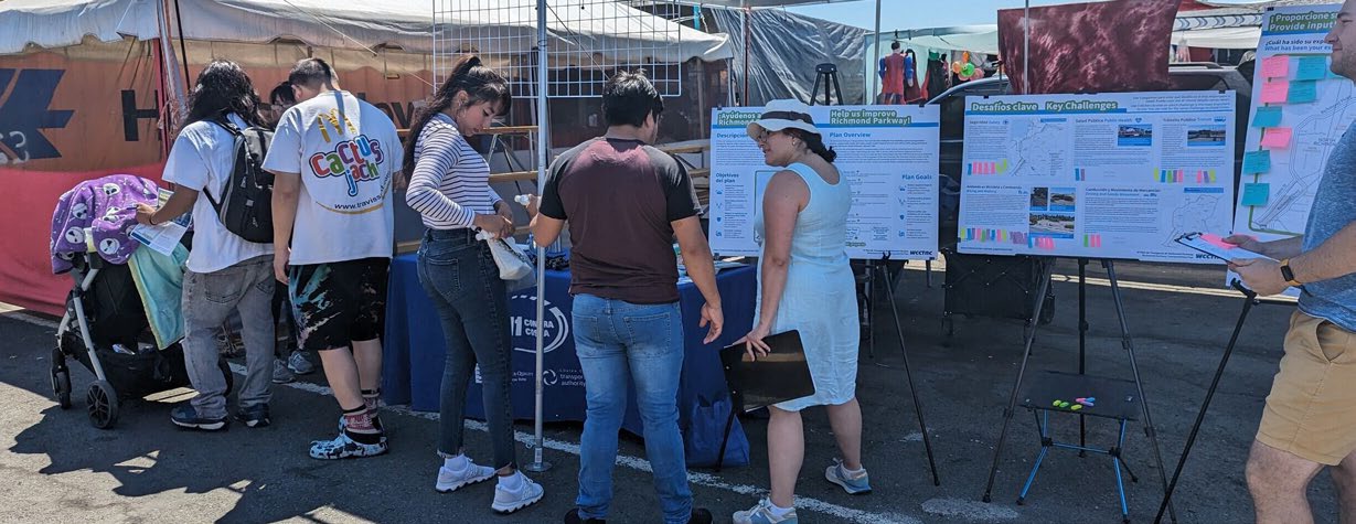 Residents reviewing Richmond Parkway engagement boards under community outreach tents